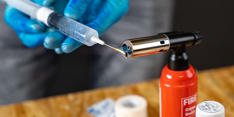 Esterilizar a agulha da seringa de esporos com uma chama Esterilizar a agulha da seringa de esporos com uma chama