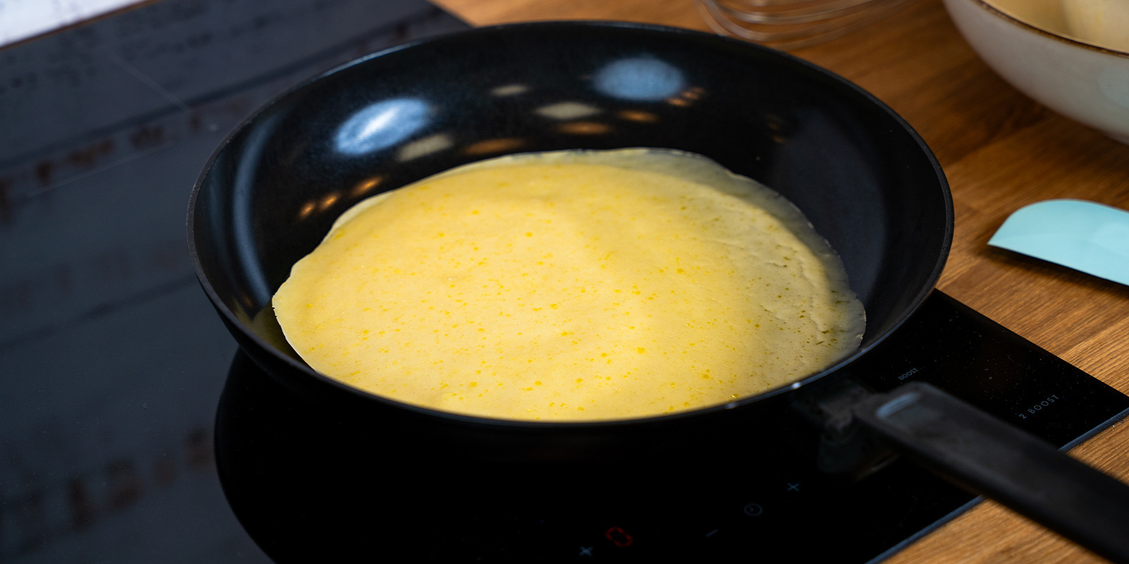 Use the soup ladle to pour pancake batter into the pan
